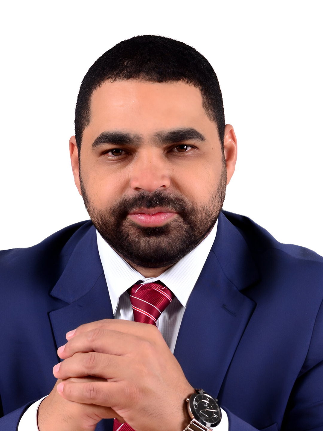 Foto de homem com terno e gravata, fundo claro, rosto sério e barba aparada